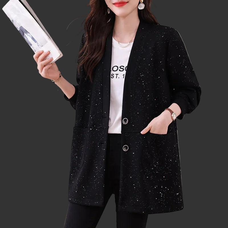 白Tシャツに合わせたブラックのロングニットジャケット着用姿、雑誌を持つ女性